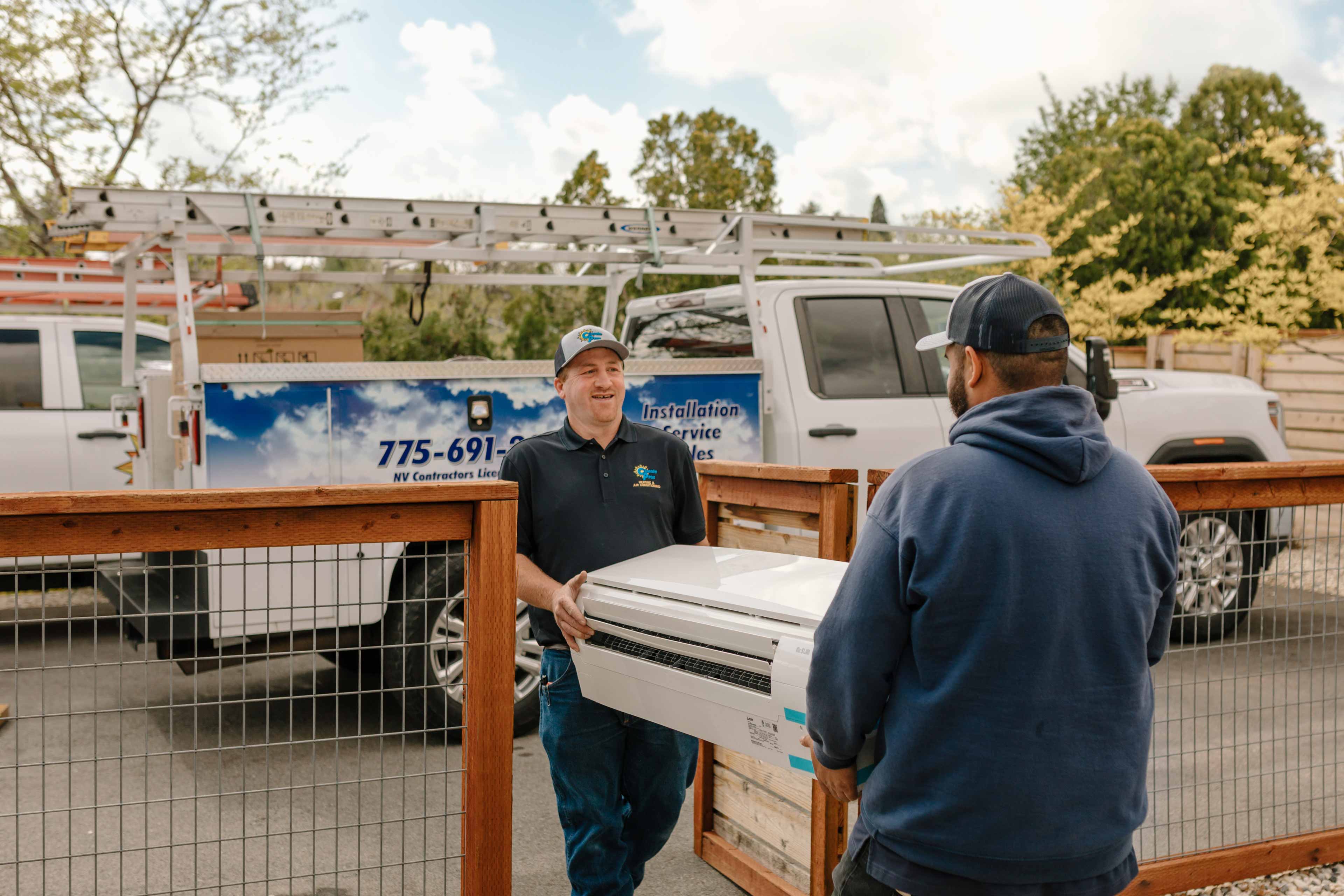 climate pros technicians carrying a new ac unit