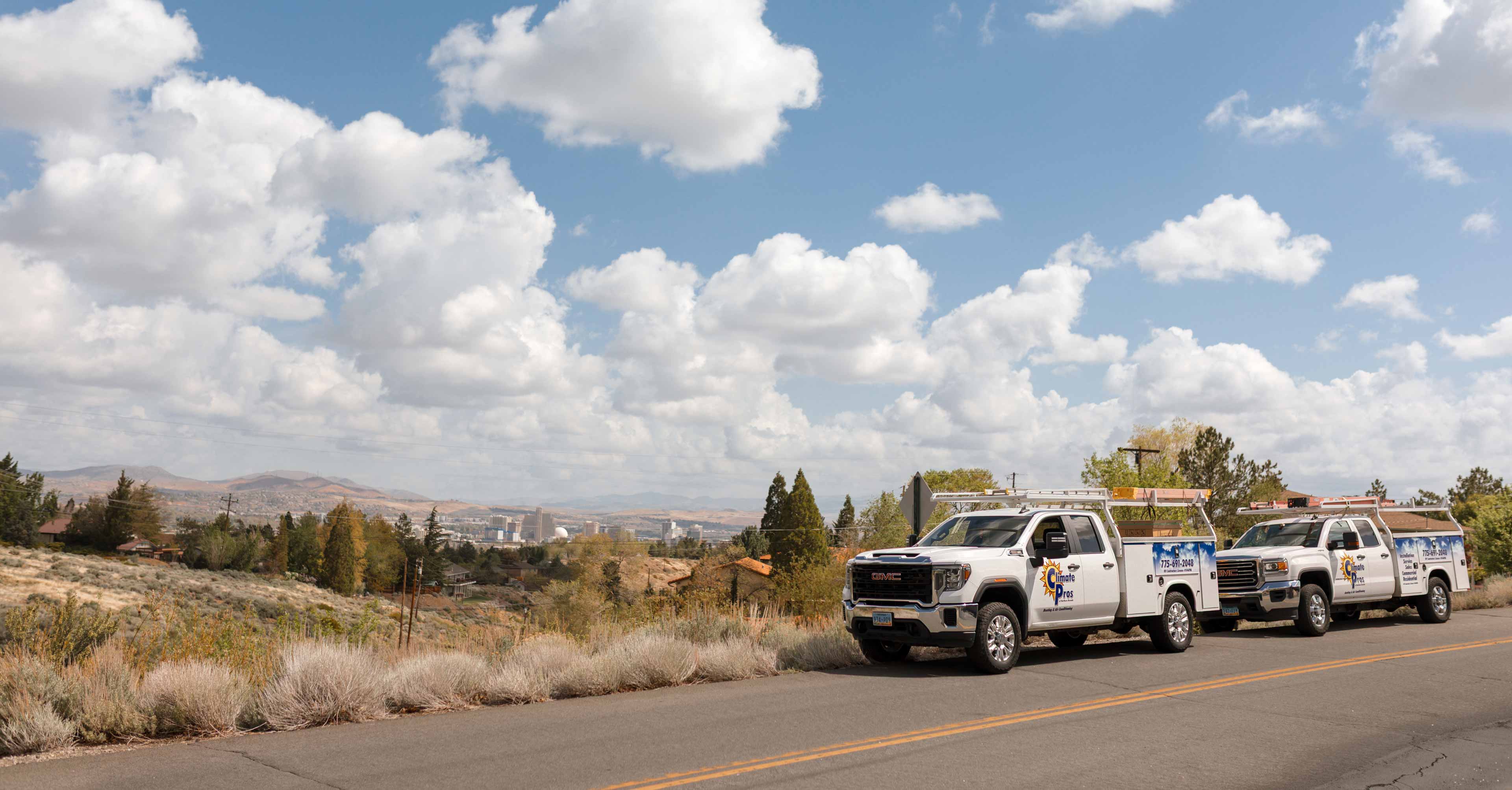 climate pros trucks with the reno city landscape in the background