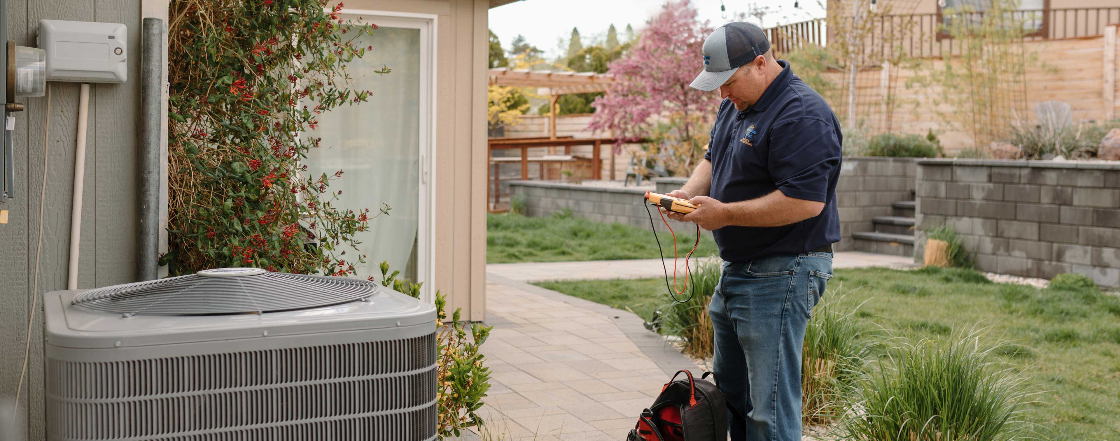 climate pros tech checking a machine with his multimeter