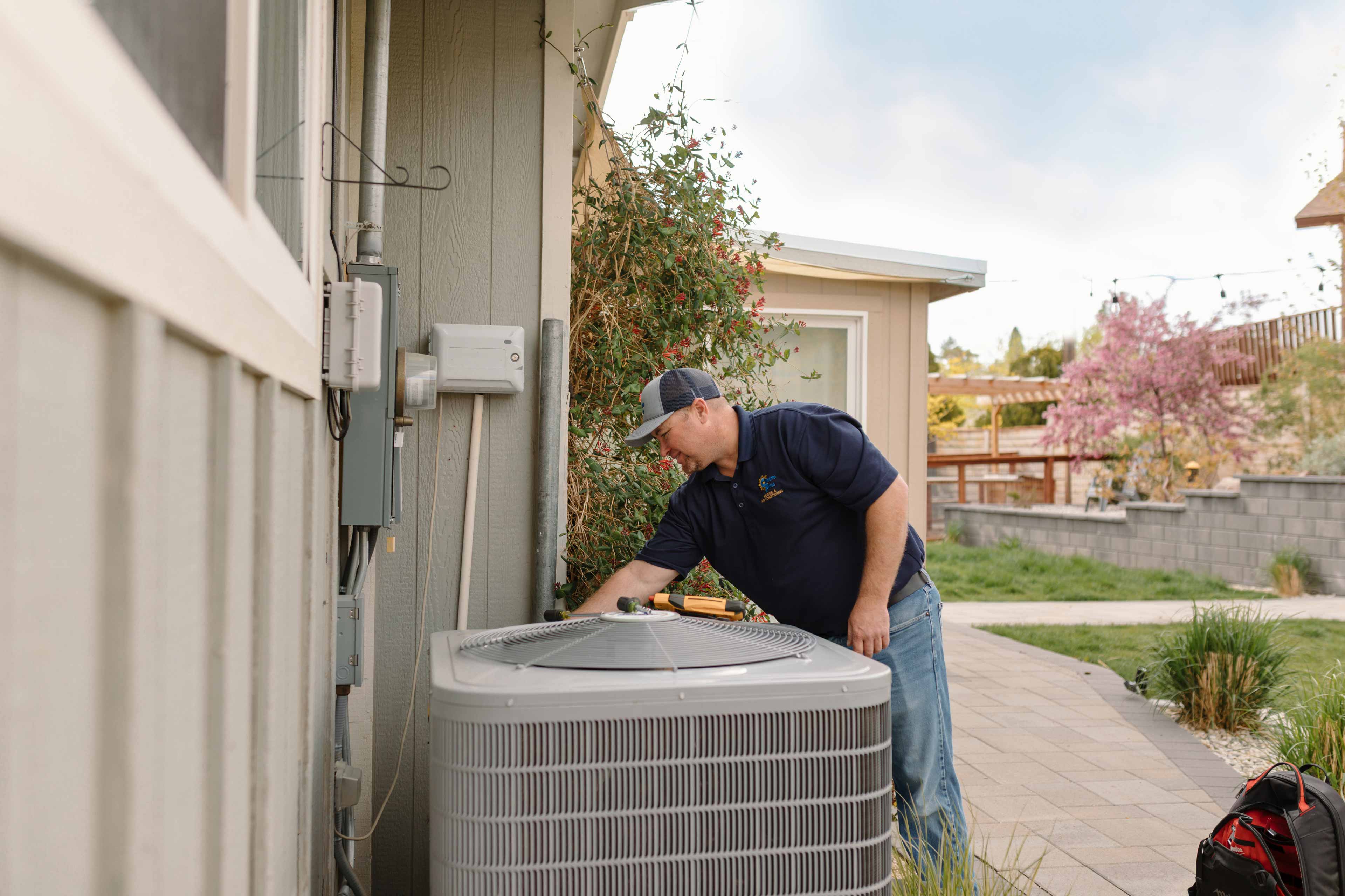 climate pros tech doing a maintenance round to an ac unit