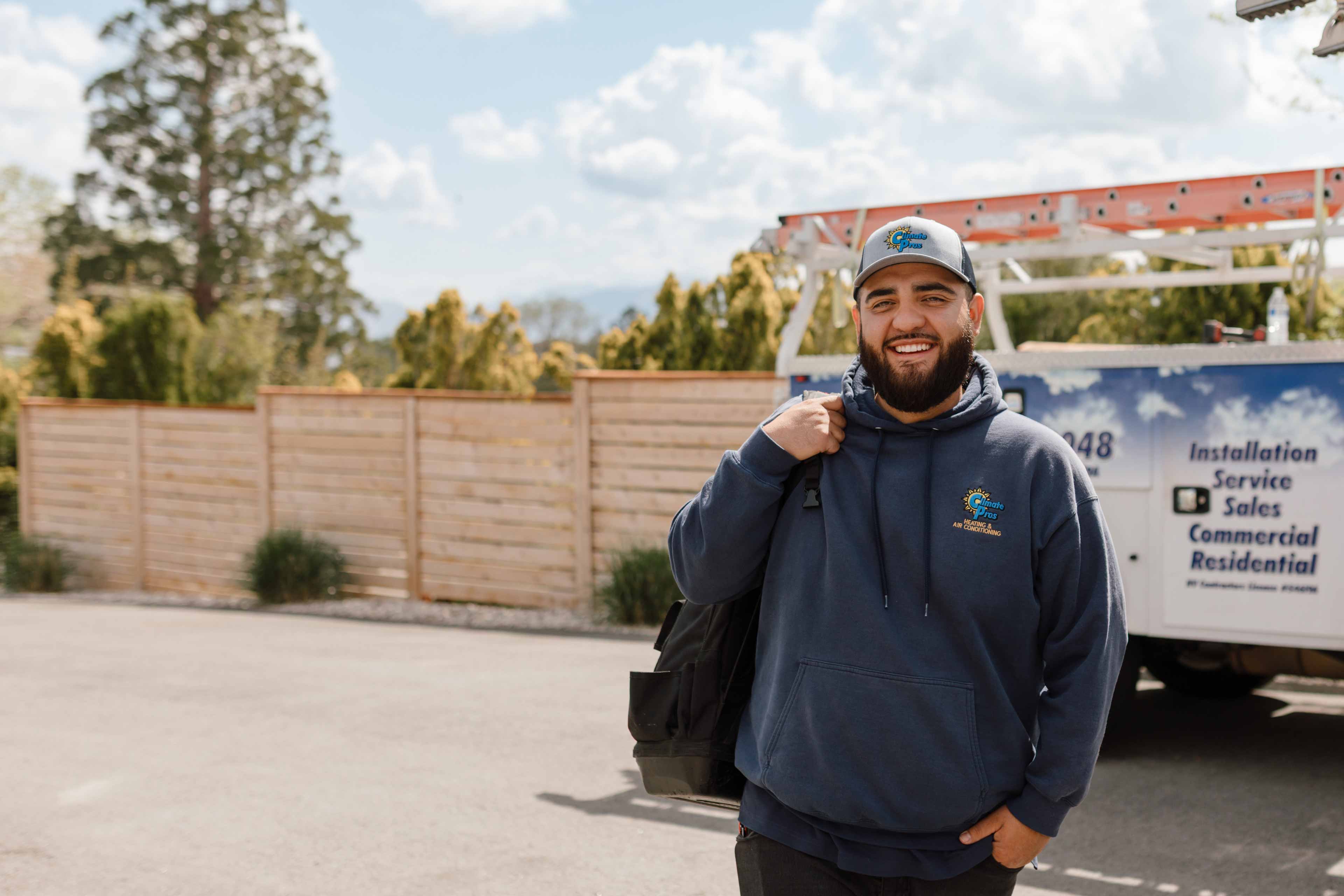 climate pros tech standying in front of their work truck