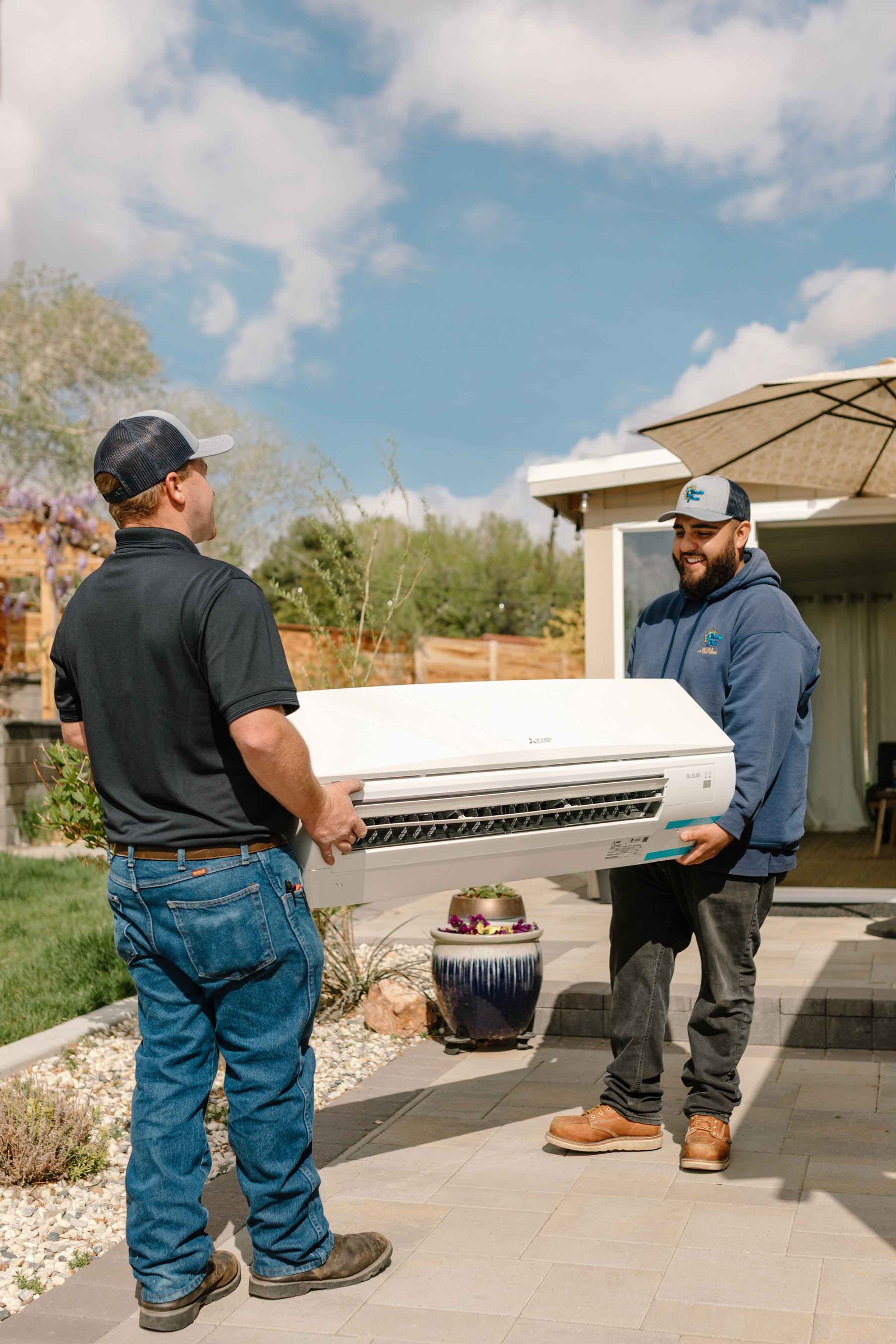 climate pros tech carrying a new ac unit