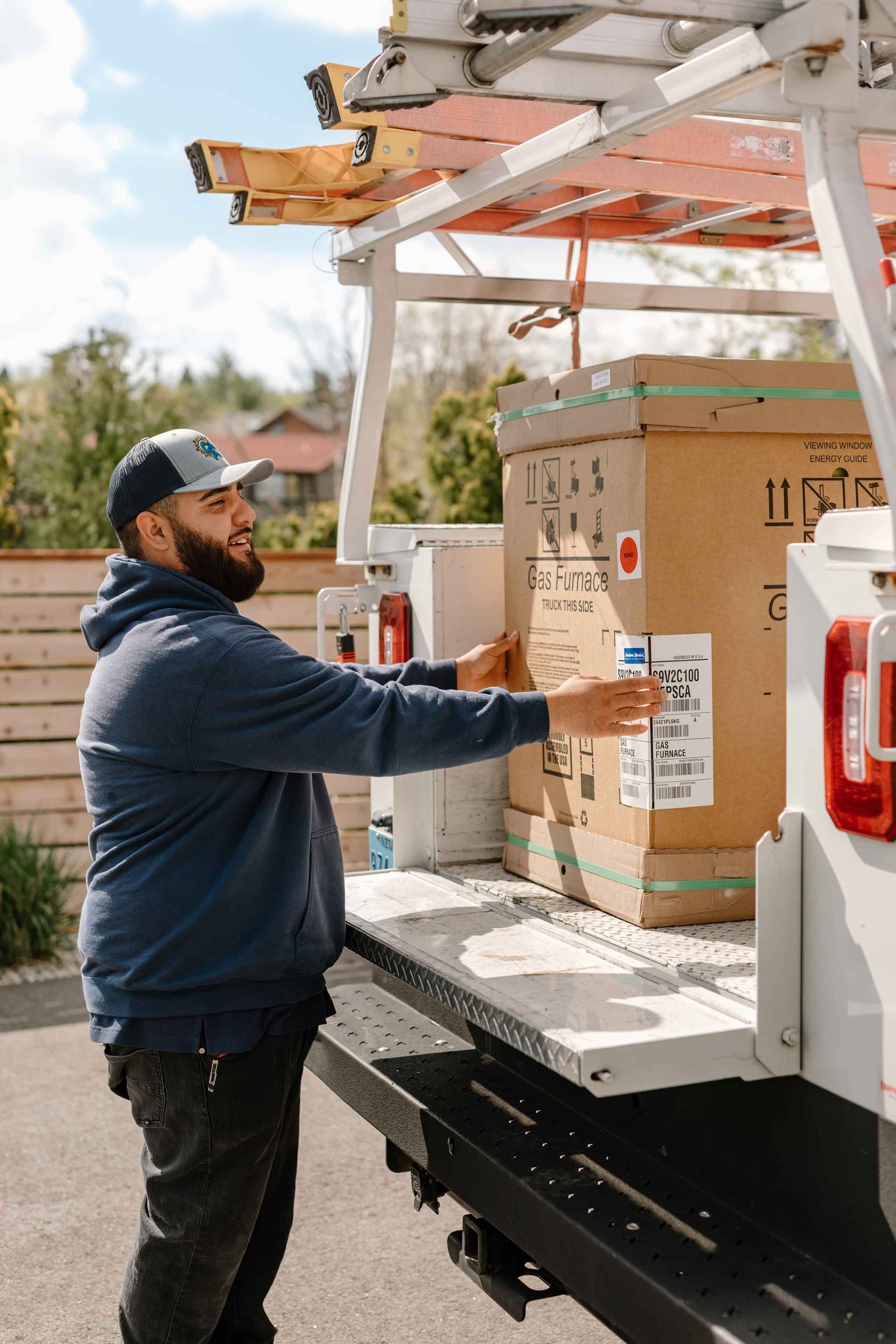 climate pros tech unloading a new gas furnace at a clients house