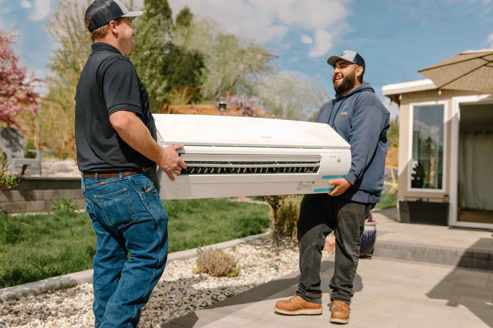 climate pros techs unloading an ac unit for a new installation