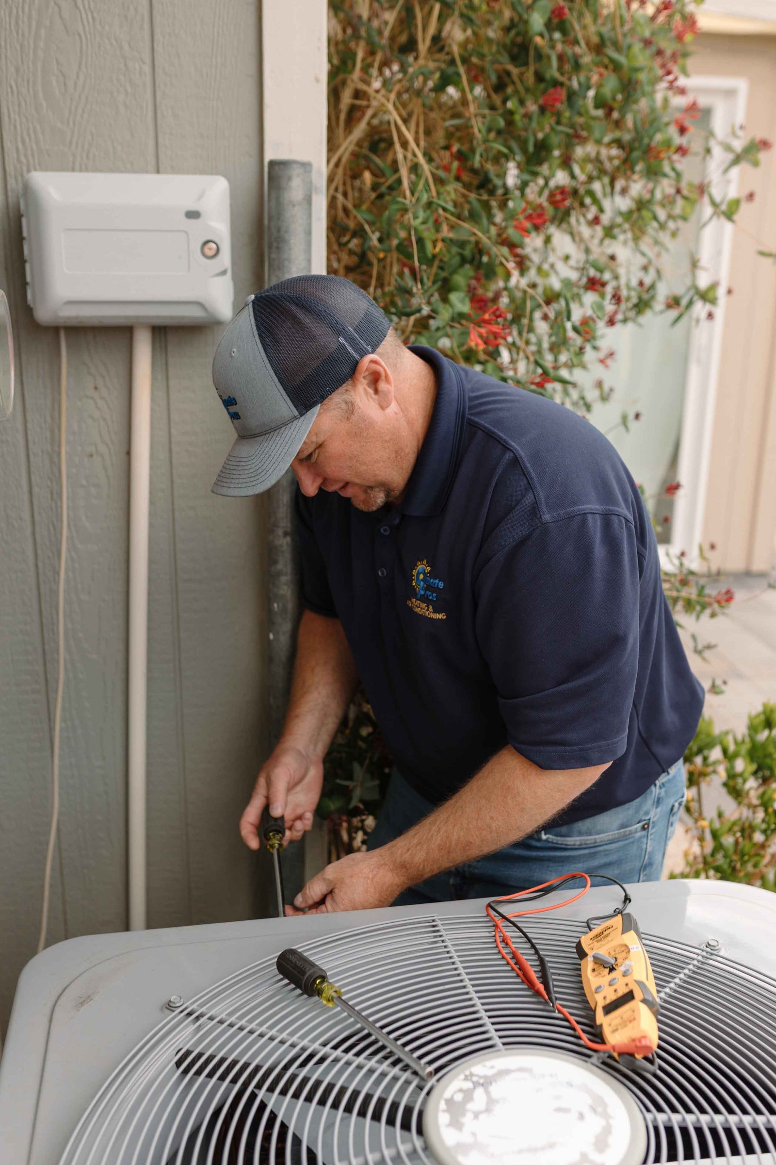 hvac technician doing preventive maintenance on an ac unit