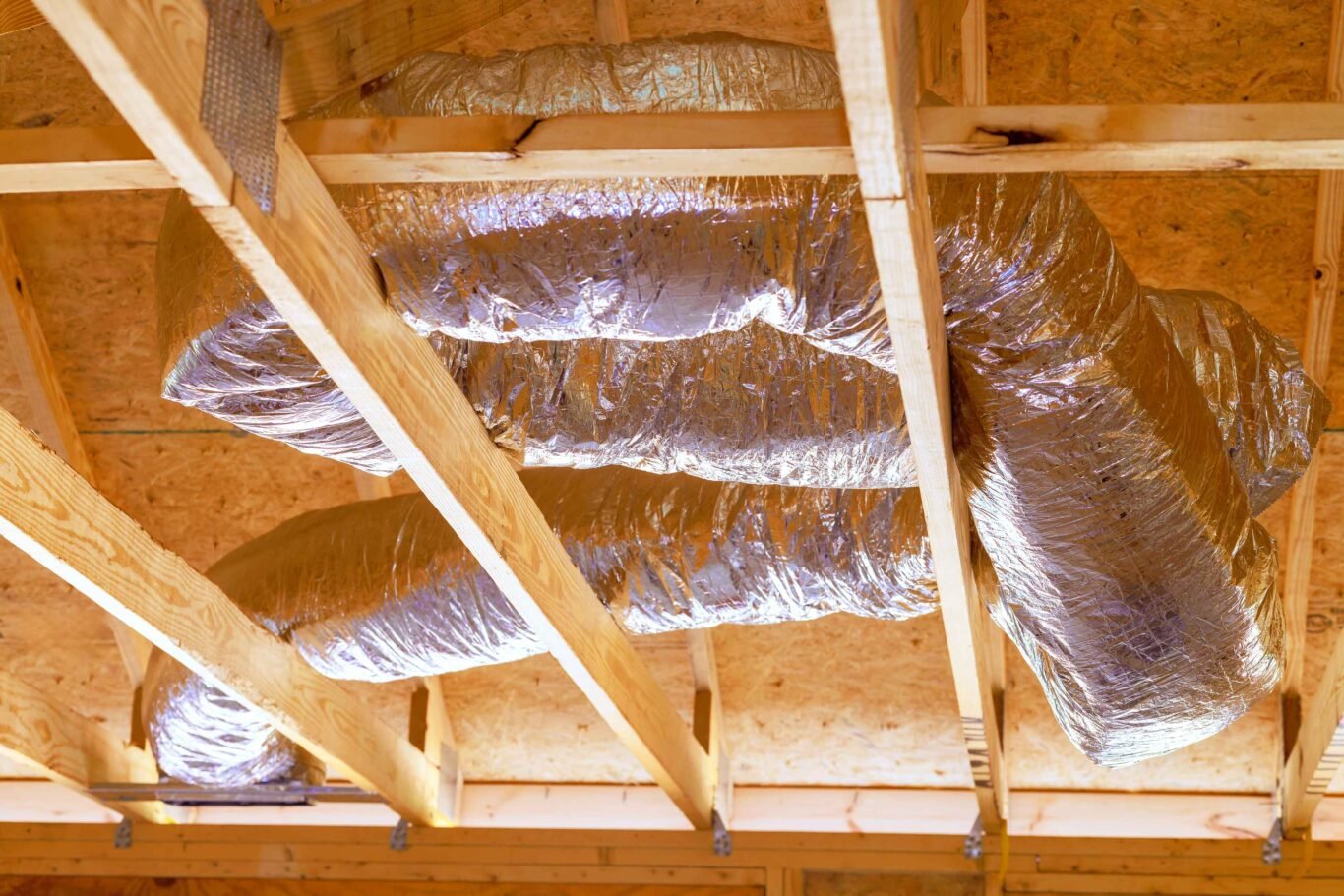 installing-ventilation-hvac-pipes-with-silver-insulation